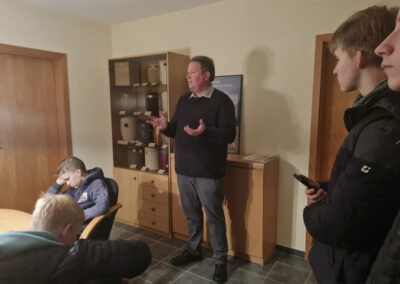 Ingo Tiefensee während eines Informationsgesprächs vor einem Urnenausstellungsschrank im Bestattungshaus Schulte Nordholt mit einer Jugendgruppe