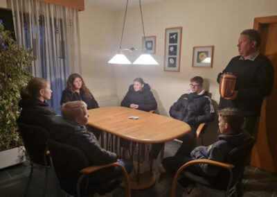 Ingo Tiefensee im Gesprächsraum des Bestattungshauses Schulte Nordholt während einer Bildungsveranstaltung mit einer Jugendgruppe und eine Urne präsentierend
